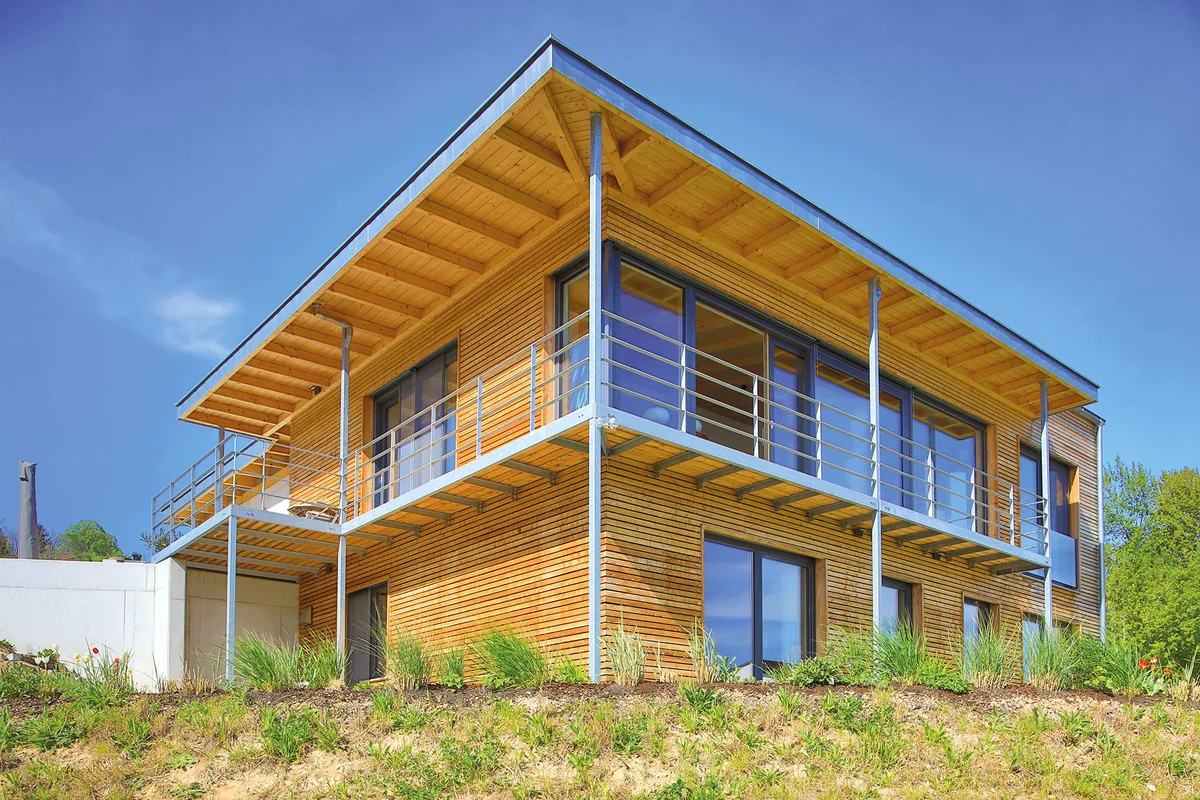 Modernes Holzhaus mit Übereck-Balkon und Pultdach. © Brunthaler Naturhausmanufaktur