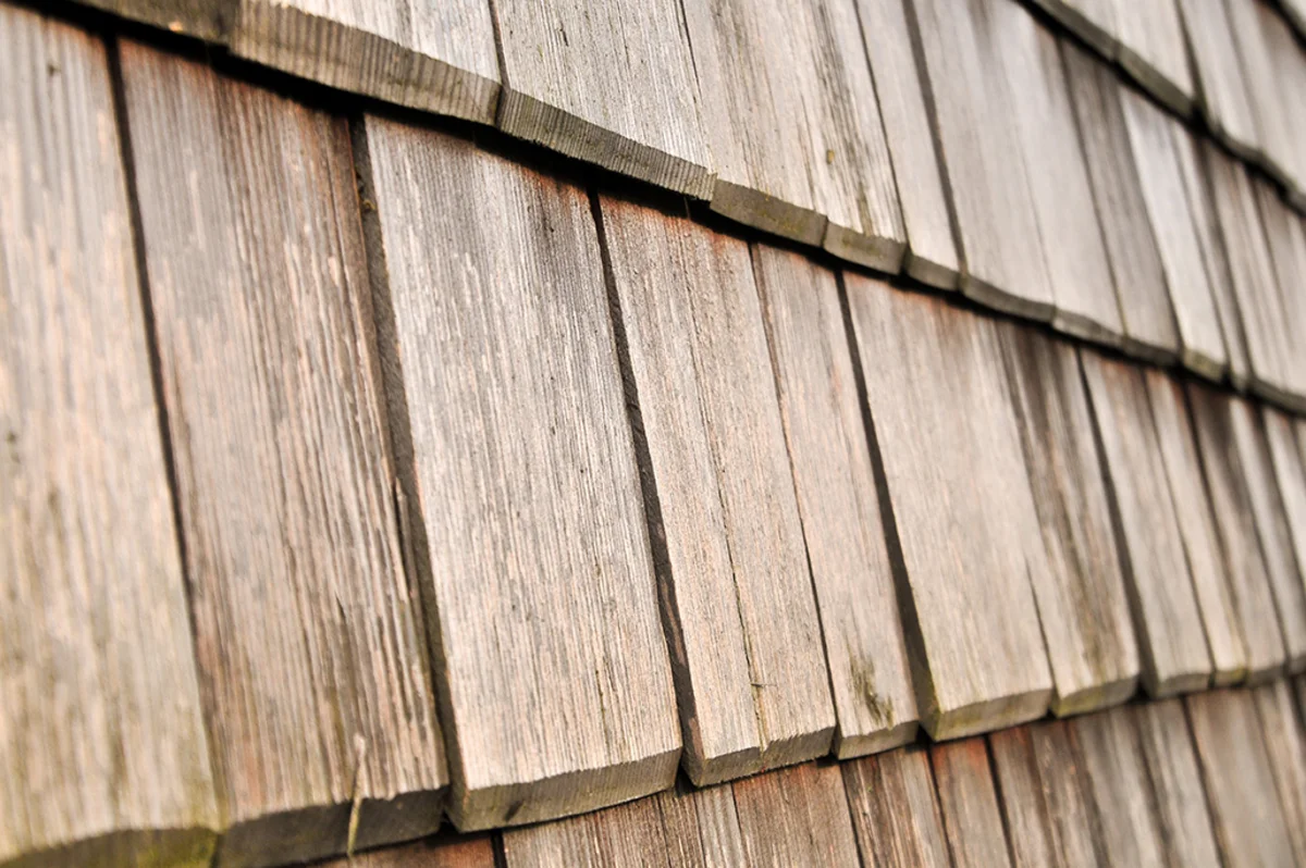 Nahaufnahme einer vergrauten Holzschindelfassade eines Massivholzhauses. © Brunthaler Naturhausmanufaktur