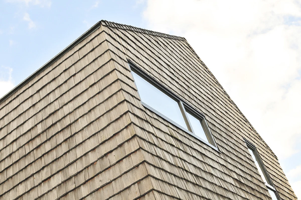 Modernes Massivholzhaus mit vergrauter Holzschindelfassade ohne Dachüberhang. © Brunthaler Naturhausmanufaktur