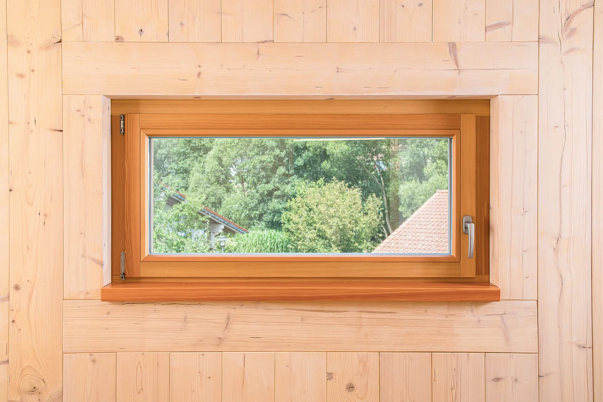 Detailaufnahme des Holzfensters in der Holzwand. © Brunthaler Naturhausmanufaktur